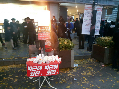한 상인이 19일 서울 광화문 4차 촛불집회에서 ‘그네 똥값, 촛불 천원’ 푯말을 걸고 집회 참가자들에게 양초를 팔고 있다. /양사록기자