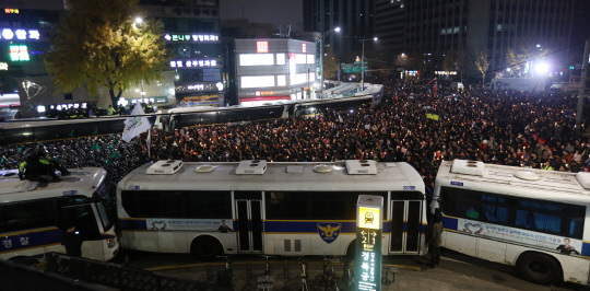 (서울=연합뉴스) 한상균 기자 = 19일 밤 박근혜 대통령 퇴진 촉구 촛불집회에 참가한 시민들이 청와대 방향인 종로구 내자동로터리에서 경찰과 대치하고 있다.
