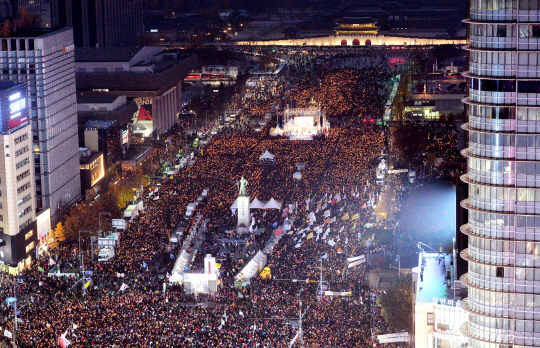 19일 오후 서울 광화문광장에서 ‘최순실 게이트’ 진상규명과 박근혜 대통령 퇴진을 촉구하는 4차 ‘2016 민중 총궐기 대회’에 참석한 시민들이 촛불을 들고 있다./사진공동취재단