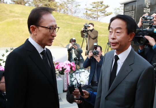 이명박(왼쪽) 전 대통령이 고(故) 김영삼 전 대통령 서거 1주기를 하루 앞둔 21일 오후 서울 동작구 국립서울현충원에서 김 전 대통령 묘소를 참배한 뒤 김 전 대통령의 차남 현철씨와 대화하고 있다.  /연합뉴스