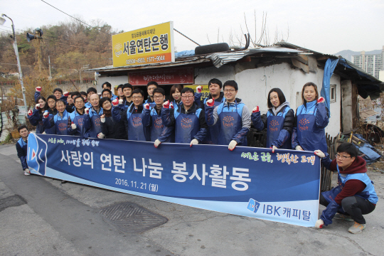 유석하(앞줄 왼쪽 다섯번째)IBK캐피탈 대표와 임직원들이 21일 서울 노원구 중계본동 백사마을에서 연탄 나눔 봉사활동을 실시한 뒤 기념촬영을 하고 있다./사진제공=IBK기업은행