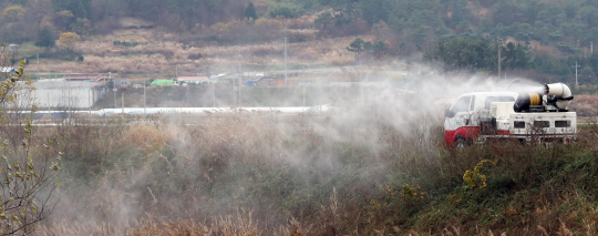 22일 오전 전남 함평군 대동면 대동저수지 인근에서 방역차량이 조류 인플루엔자(AI)를 퍼뜨리는 주범으로 지목된 철새를 대상으로 한 방역을 실시하고 있다. /연합뉴스