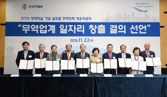 한국무역협회가 22일 ‘2016 글로벌 무역인력 채용박람회’를 개최하고 김인호(왼쪽 다섯번째) 무역협회장 등 참석자들이 ‘무역업계 일자리 창출 결의 선언’ 서명식을 갖고 있다. /사진제공=한국무역협회