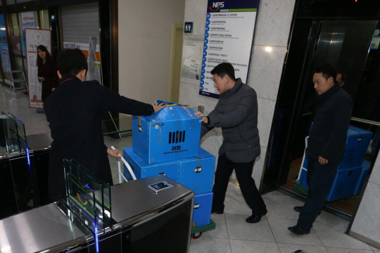 국민연금의 삼성물산-제일모직 합병 찬성 논란과 관련해 23일 서울 논현동 국민연금 기금운용본부를 압수수색한 검찰이 압수물을 들고 나오고 있다. /연합뉴스