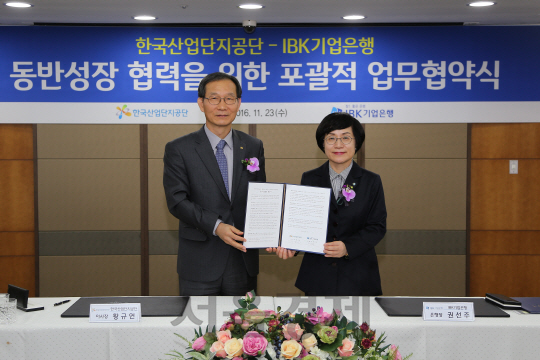 황규연(왼쪽)산단공 이사장과 권선주 IBK기업은행장이 23일 IBK은행 본점에서 동반성장 협력을 위한 업무협약을 체결한 뒤 체결서를 들어보이고 있다./ 사진제공=산단공