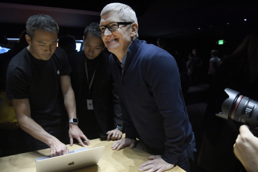 팀 쿡(가운데) 애플 최고경영자(CEO)가 지난달 말 출시된 맥북 프로 신제품 발표회에서 포즈를 취했다./블룸버그통신