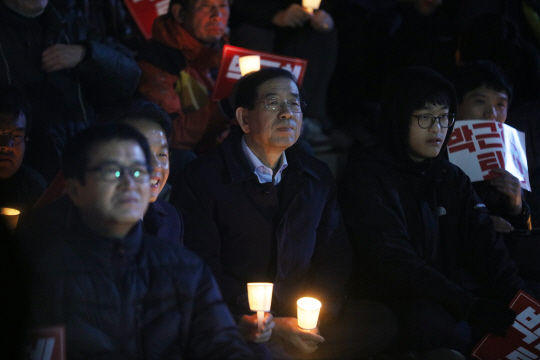 지난 2일 오후 서울 청계광장 인근에서 열린 박근혜 대통령 하야 촉구 촛불집회에 참석한 박원순 서울시장이 한 시민과 촛불을 나누고 있다./연합뉴스