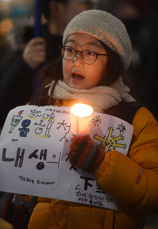 박근혜 대통령 퇴진촉구 촛불집회가 열린 26일 오후 서울 청운효자동 주민센터 앞에서 한 어린이가 촛불을 들고 서 있다./권욱기자ukkwon@sedaily.com