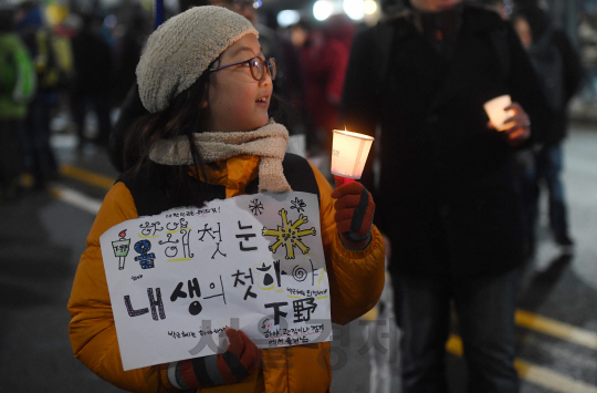 박근혜 대통령 퇴진촉구 촛불집회가 열린 26일 오후 서울 청운효자동 주민센터 앞에서 한 어린이가 촛불을 들고 서 있다./권욱기자ukkwon@sedaily.com