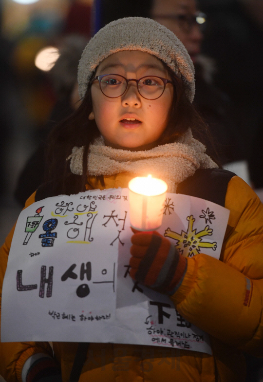 박근혜 대통령 퇴진촉구 촛불집회가 열린 26일 오후 서울 청운효자동 주민센터 앞에서 한 어린이가 촛불을 들고 서 있다./권욱기자ukkwon@sedaily.com