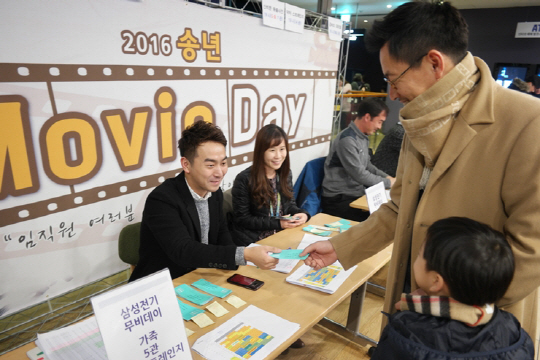 삼성전기 직원이 아들과 무비데이 입장권을 받고 있다. /사진제공=삼성전기