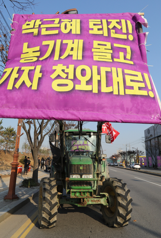 전국농민회총연맹(전농)의 트랙터들이 ‘박근혜 퇴진’ 현수막을 건 채 지난 25일 오후 평택대학교 앞을 지나 서울로 올라오고 있다.   　 /안성=연합뉴스