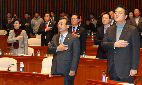 이정현 새누리당 대표와 정진석 원내대표가 29일 오후 국회에서 열린 의원총회에서 국기에 대한 경례를 하고 있다. 정 원내대표는 이 자리에서 “개헌이 이뤄지면 헌법 개정 절차에 따라서 대통령의 질서 있는 조기 퇴진이 이뤄질 수 있다”며 개헌론에 다시 불을 지폈다.  /연합뉴스