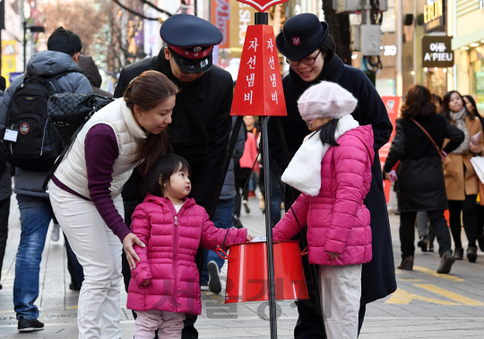 구세군 자선냄비 모금 활동이 시작된 1일 서울 명동을 찾은 시민들이 구세군 자선냄비에 불우이웃 돕기 성금을 내고 있다./권욱기자ukkwon@sedaily.com