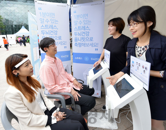 옴니씨앤에스가 최근 서울광장에서 열린 ‘2016 서울시민 건강한마당’ 행사에서 스트레스 및 두뇌 건강 측정 기구 ‘옴니핏’을 시연하고 있다/사진제공=옴니씨앤에스