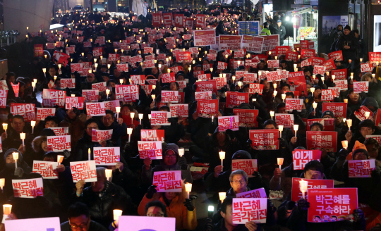 박근혜 대통령이 3차 담화문을 발표한 29일 밤 서울 파이낸스 빌딩 앞에서 박 대통령의 퇴진을 주장하는 철조노조 조합원들과 시민들이 촛불집회를 열고 대통령 퇴진 구호를 외치고 있다. /연합뉴스