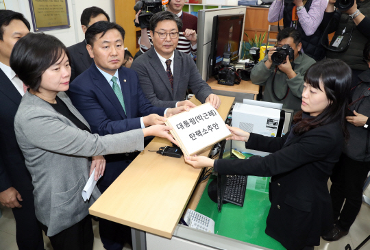 이춘석(오른쪽부터) 더불어민주당 탄핵추진실무단장, 김관영 국민의당 탄핵추진단장, 이정미 정의당 탄핵추진단장이 3일 새벽 국회 의안과에 ‘박근혜 대통령 탄핵소추안’을 제출하고 있다. 탄핵소추안은 민주당 121명, 국민의당 38명, 정의당 6명, 무소속 6명 등 총 171명의 의원이 참여했다. /연합뉴스