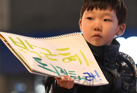 6차 촛불집회가 열린 3일 오후 한 어린이가 자신이 직접 적은 퇴진 문구를 들고 서울 광화문 광장에서 청와대 방면으로 행진하고 있다./송은석기자songthomas@sedaily.com