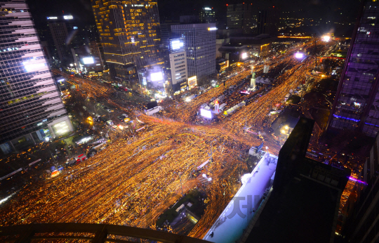 3일 오후 서울 광화문광장에서 열린 박근혜 대통령 퇴진을 요구하는 6차 주말 촛불집회에 참가한 시민들이 촛불을 들고 청와대 방향으로 행진하고 있다./사진공동취재단