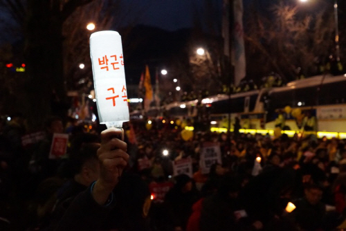 한 시민이 LED로 만든 촛불을 들고 ‘박근혜 구속’을 외치고 있다. / 강신우PD