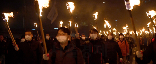 6차 촛불집회가 열린 3일 오후 횃불을 든 시민들이 서울 광화문 광장에서 청와대 방면으로 행진하고 있다./송은석기자songthomas@sedaily.com