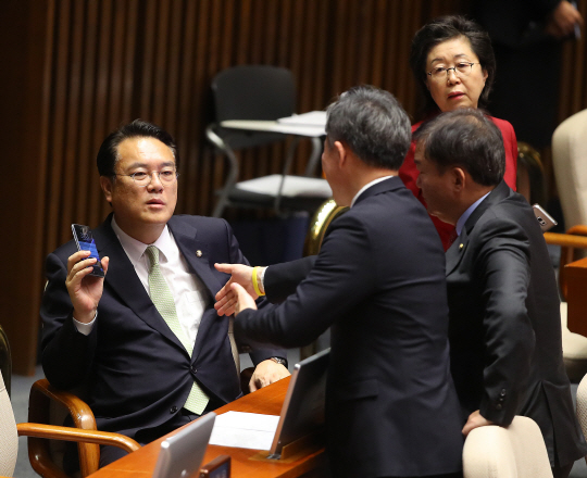 표창원(가운데) 더불어민주당 의원이 1일 국회 본회의장에서 정진석(왼쪽) 새누리당 원내대표와 민경욱 의원에게 탄핵 반대의원 명단 공개에 대한 항의를 받고 있다. /연합뉴스