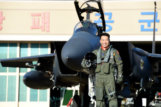 2016 탑건의 영예를 안은 김학선 소령이 F-15K 전투기 앞에서 활짝 웃고 있다./ 사진제공=공군
