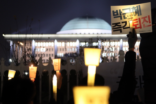 박근혜 대통령의 탄핵소추안 표결을 이틀 앞둔 7일 저녁 국회 앞에서 열린 ‘국민과 함께하는 촛불 문화제’에서 참가자들이 박근혜 대통령의 탄핵을 촉구하는 촛불을 들고 있다./연합뉴스
