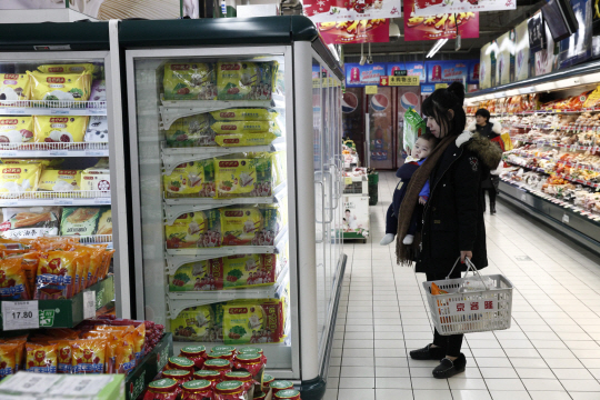지난 8일 중국 수도 베이징의 한 슈퍼마켓에서 아이를 안은 여성이 진열된 상품을 살펴보고 있다. 중국 국가통계국은 9일 11월 소비자 물가지수(CPI)가 전년 같은 기간에 비해 2.3% 올랐으며 채소와 휘발유, 여행·교육 서비스 가격 등이 지수를 끌어올렸다고 분석했다./베이징=EPA연합뉴스