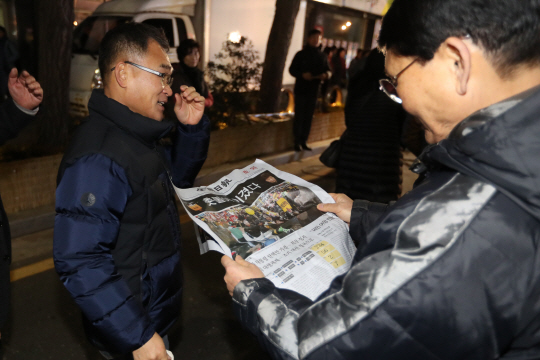 박근혜 대통령 탄핵안이 국회에서 가결된 9일 오후 광주 동구 금남로에서 시민이 지역신문 호외판을 살펴보고 있다./연합뉴스