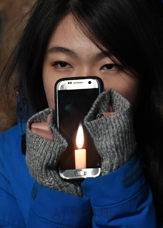 10일 오후 서울 광화문 광장에서 열린 7차 민중총궐기에 한 시민이 스마트폰을 이용해 촛불을 들어보이고 있다./송은석기자songthomas@sedaily.com