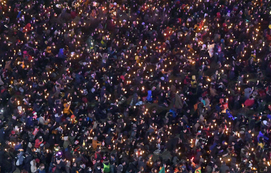 박근혜 대통령 탄핵소추안이 가결된 다음 날인 10일 광화문 광장에 모인  시민이 촛불을 밝히고 '박근혜 대통령 즉각 퇴진' 구호를 외치고 있다./이호재기자.