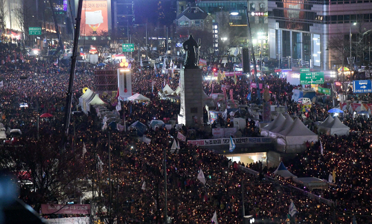 박근혜 대통령 탄핵소추안이 가결된 다음 날인 10일 광화문 광장에 모인  시민이 촛불을 밝히고 '박근혜 대통령 즉각 퇴진' 구호를 외치고 있다. /이호재기자
