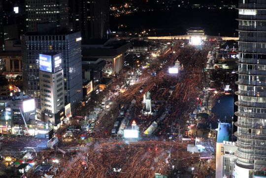 박근혜 대통령 탄핵소추안이 가결된 다음 날인 10일 광화문 광장에 모인 시민이 촛불을 들고 행진하고 있다./사진공동취재단
