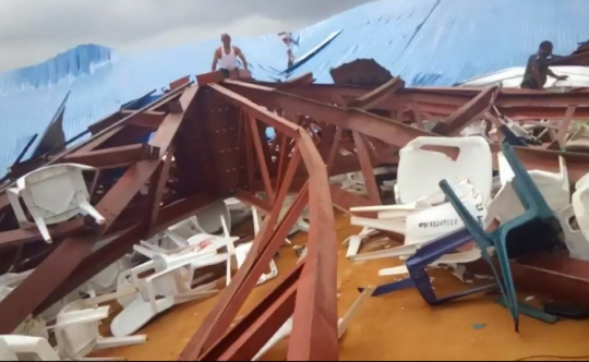 10일(현지시간) 나이지리아 우요의 한 교회 천장이 서품식 진행 중에 천장이 무너져 내렸다. 구조에 나선 사람들이 휘어진 철골 사이로 생존자를 찾고 있다./우요=AP연합뉴스
