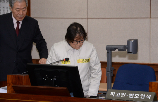 19일 오후 국정농단 관련 첫 재판이 열린 서울중앙지법 대법정에 최순실씨가 이경재 변호사와 함께 자리에 앉고 있다. /사진공동취재단