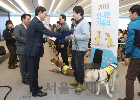 20일 서초동 삼성금융연수원에서 열린 기증식에서 김동현씨가 안내견 몽실을 기증받고 있다. /사진제공=삼성화재