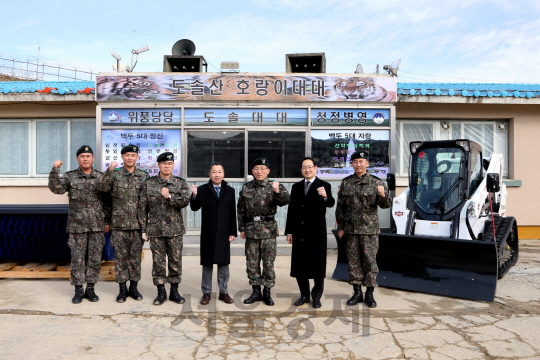 박정원(왼쪽 네번째) 두산그룹 회장이 21일 강원도 양구 백두산 부대를 방문해 두산밥캣 컴팩트 트랙로더와 어태치먼트를 기증하고 부대 관계자들과 함께 기념촬영을 하고 있다./사진제공=두산