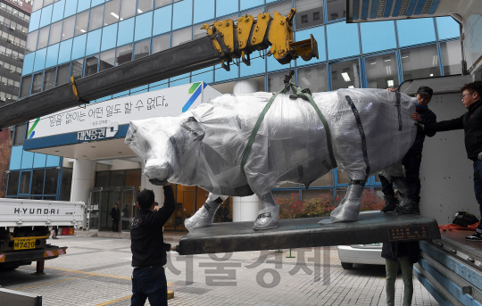 23일 서울 여의도 대신증권 본사 앞에 설치된 황소 동상이 크레인에 실려 이사차량으로 옮겨지고 있다./이호재기자.