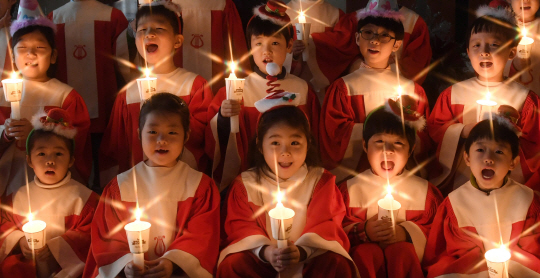 어린이 성가대원들이 손에 촛불을 들고 크리스마스 캐럴을 부르고 있다./권욱기자