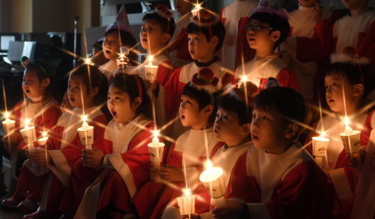 어린이 성가대원들이 손에 촛불을 들고 크리스마스 캐럴을 부르고 있다./권욱기자
