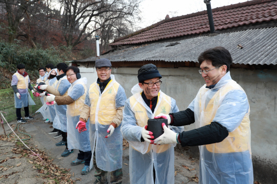 이순우(오른쪽 두번째) 저축은행중앙회장이 지난 17일 서울 도봉구 안골마을에서 소외계층을 위한 연탄나눔 봉사활동에 참여해 연탄을 직접 나르고 있다./사진제공=저축은행중앙회