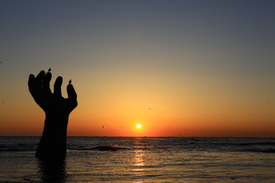 한반도에서 가장 먼저 해가 뜨는 포항 호미곶의 해오름(일출) 모습. ‘상생의 손’이라고 부르는 높이 8.5m의 구조물이 랜드마크다.