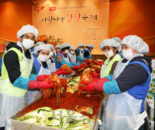 지난 11일 충남 아산시 선문대 체육관에서 열린  ‘제 12회 사랑나눔 김장축제’에 참가한 삼성디스플레이 임직원과 선문대 학생, 충남 지역 주민들이 김치 담그기에 열중하고 있다. /사진제공=삼성디스플레이