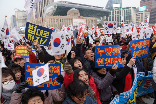 지난 24일 대한문 앞에서 ‘법대로 하자’며 더욱 거세게 태극기를 흔드는 박사모 등 보수단체 회원들. / 강신우PD