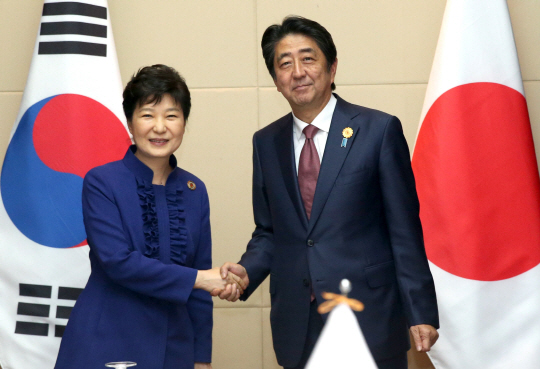 박근혜(왼쪽) 대통령과 아베 신조 일본 총리가 지난 9월 7일라오스 비엔티안 국립컨벤션센터(NCC)에서 열린 한·일 정상회담에서 악수하고 있다. /연합뉴스