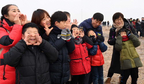 구자일(뒷줄 오른쪽 두번째)씨와 그의 아들(앞줄 오른쪽 두번째)이 지인들과 함께 1일 서울 마포 하늘공원에서 밝아진 새해 첫날 하늘을 향해 환호성을 지르고 있다. /권욱기자