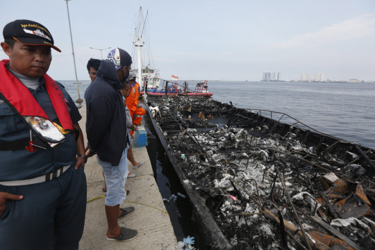 인도네시아 구조대원이 1일 인도네시아 자카르타 근처 해상에서 불에 탄 여객선을 바라보고 있다. 이날  화재로 최소 23명이 사망했다.  /자카르타=EPA연합뉴스