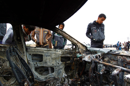 이라크 나자프에서 1일(현지시간) 시민들이 자살폭탄테러로 불탄 차량을 살펴보고 있다. /나자프=AFP연합뉴스