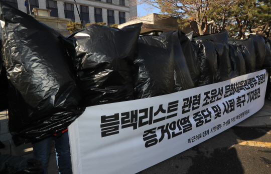 문화예술인들이 지난해 12월 29일 서울 종로구 재동 헌법재판소 앞에서 정부의 ‘블랙리스트’ 작성 의혹과 관련해 조윤선 문화체육관광부 장관 사퇴를 촉구하는 퍼포먼스를 하고 있다. 이들은 쓰고 있던 검은 비닐봉지를 찢는 행위로 ‘블랙리스트를 만든 이들에 저항하겠다’는 의지를 표현했다./사진=연합뉴스